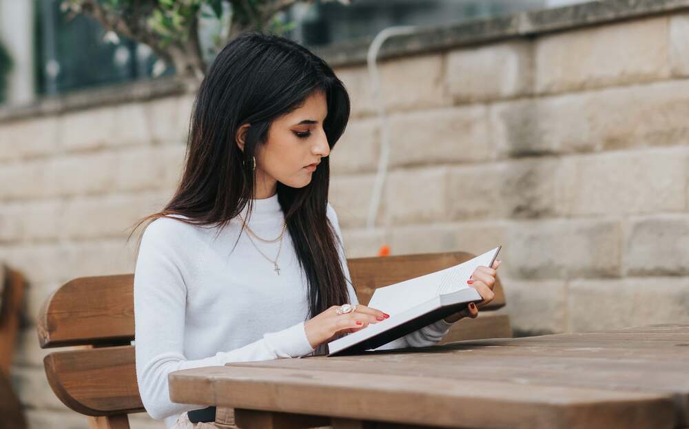 femme aux cheveux noirs qui étudient dehors